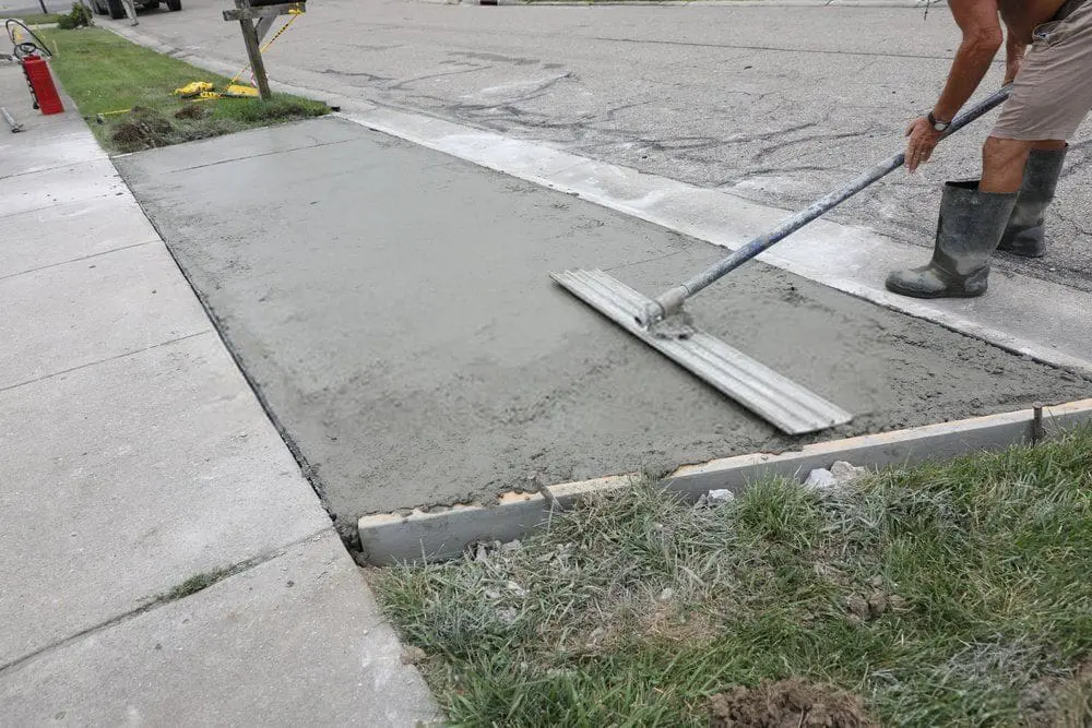Coral Gables-licensed Dade Decorative Concrete contractor leveling this driveway surface with horsehair broom